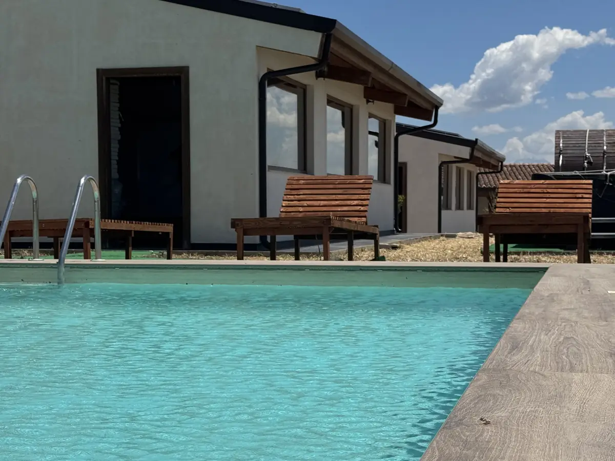 La piscina davanti al bungalow bianco