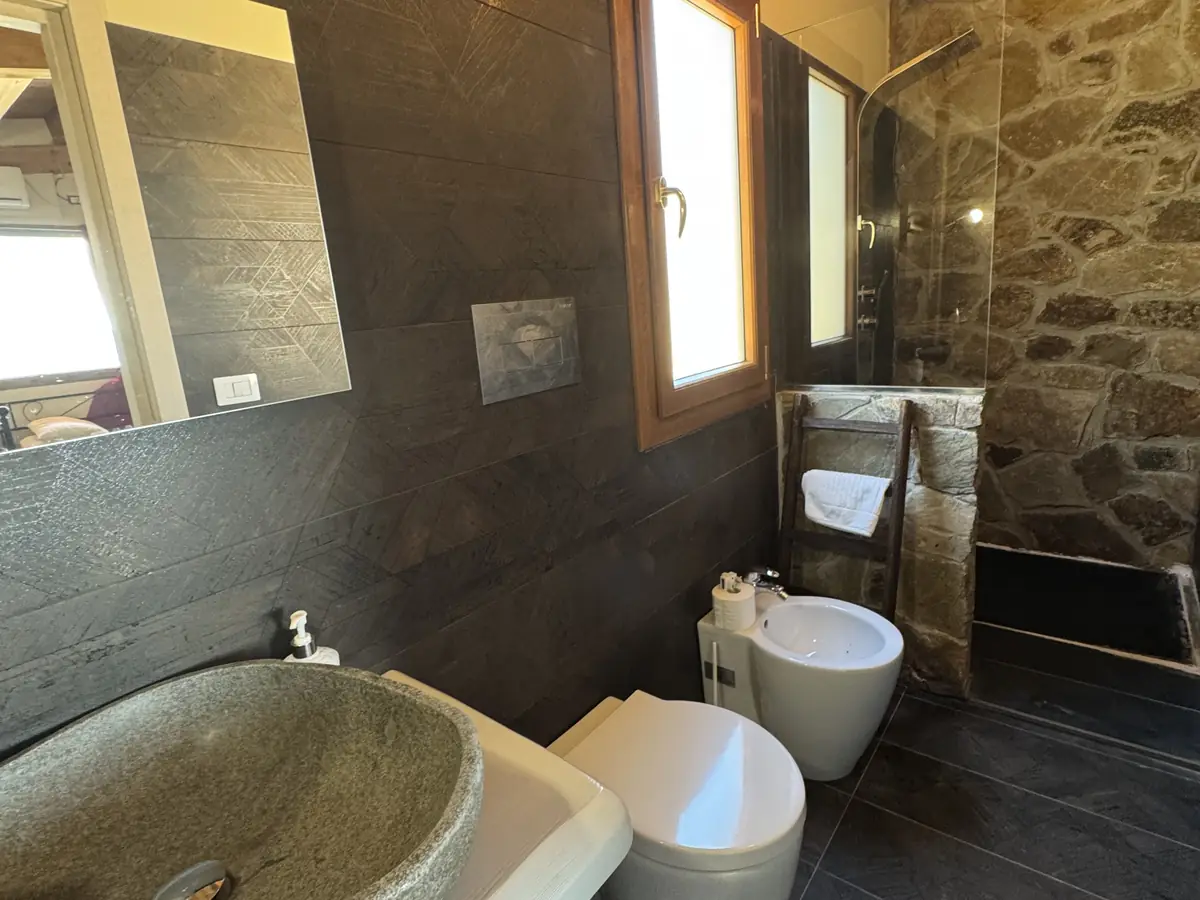 Il lavabo in pietra con lo specchio e la finestra