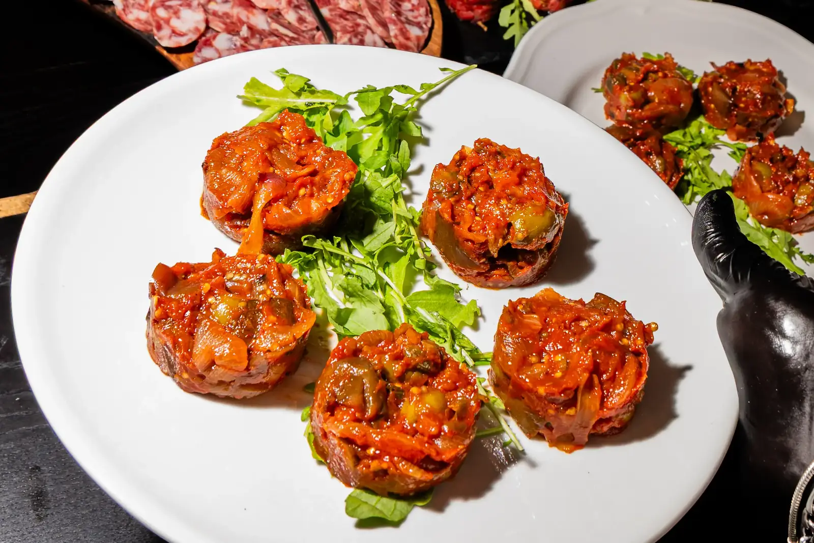 Porzioni al sugo su rucola, pronte da servire