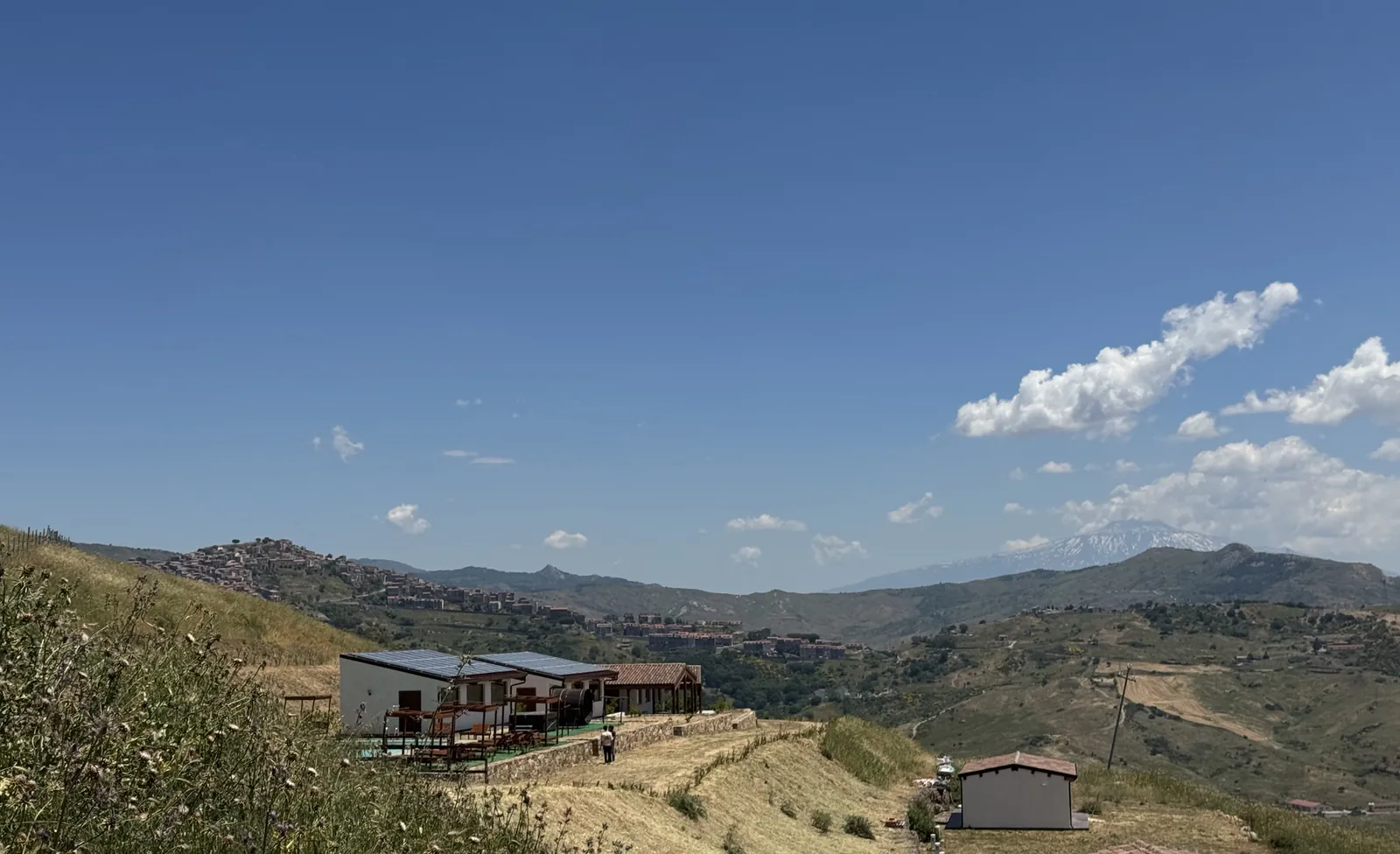 Allevatori sui Nebrodi: il crinale di Cerami con i recinti e le camere dell’agriturismo, il paese sullo sfondo