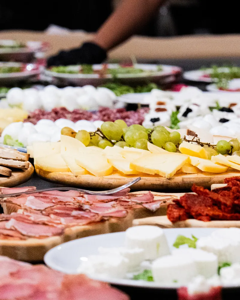 Formaggi a fette, uva, salumi e ricotte in tavola