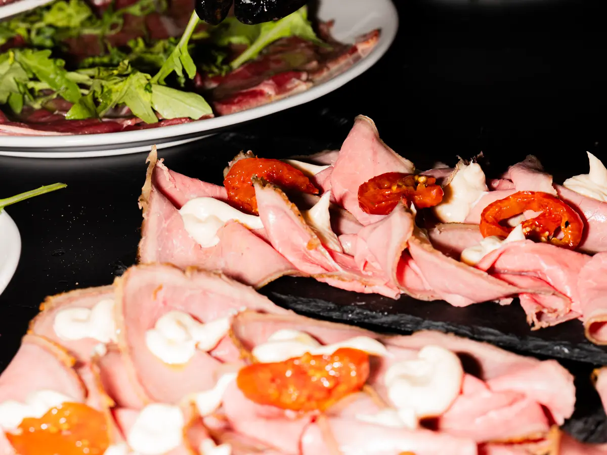 Fette di roast beef con pomodorini e mozzarella su un tagliere, in tavola